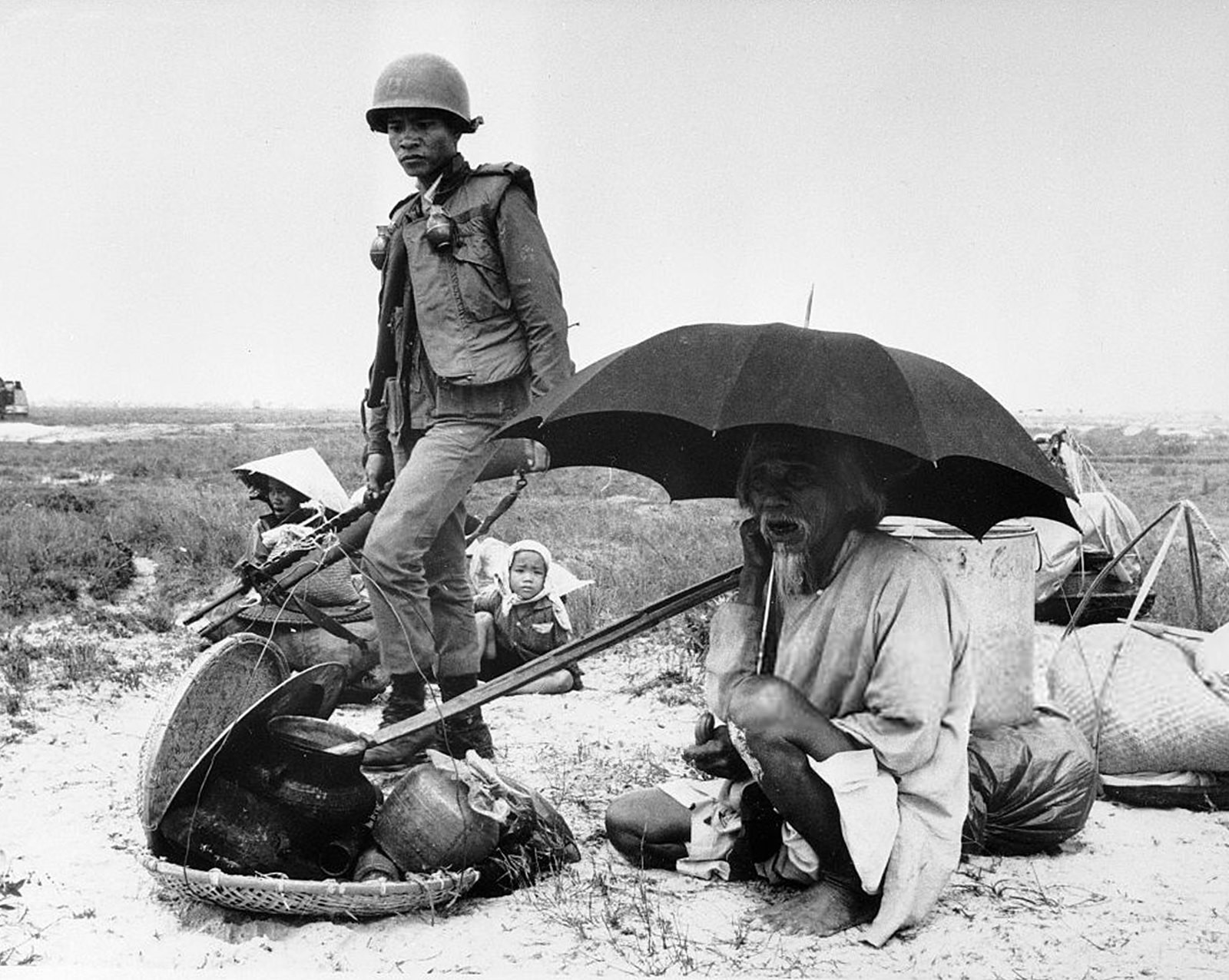 Elderly Vietnamese Man Sits Under Umbrella