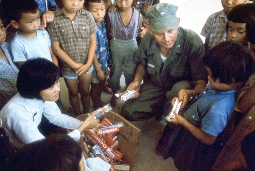 Vietnamese nurse assists Captain E.J. Lofgreen, Force Dental Officer with the Third Marine Amphibious Force, as they distribute tooth brushes and paste to the children in support of the oral hygiene and preventive dentistry program.
