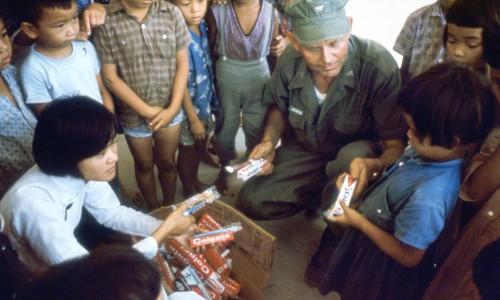 Vietnamese nurse assists Captain E.J. Lofgreen, Force Dental Officer with the Third Marine Amphibious Force, as they distribute tooth brushes and paste to the children in support of the oral hygiene and preventive dentistry program.