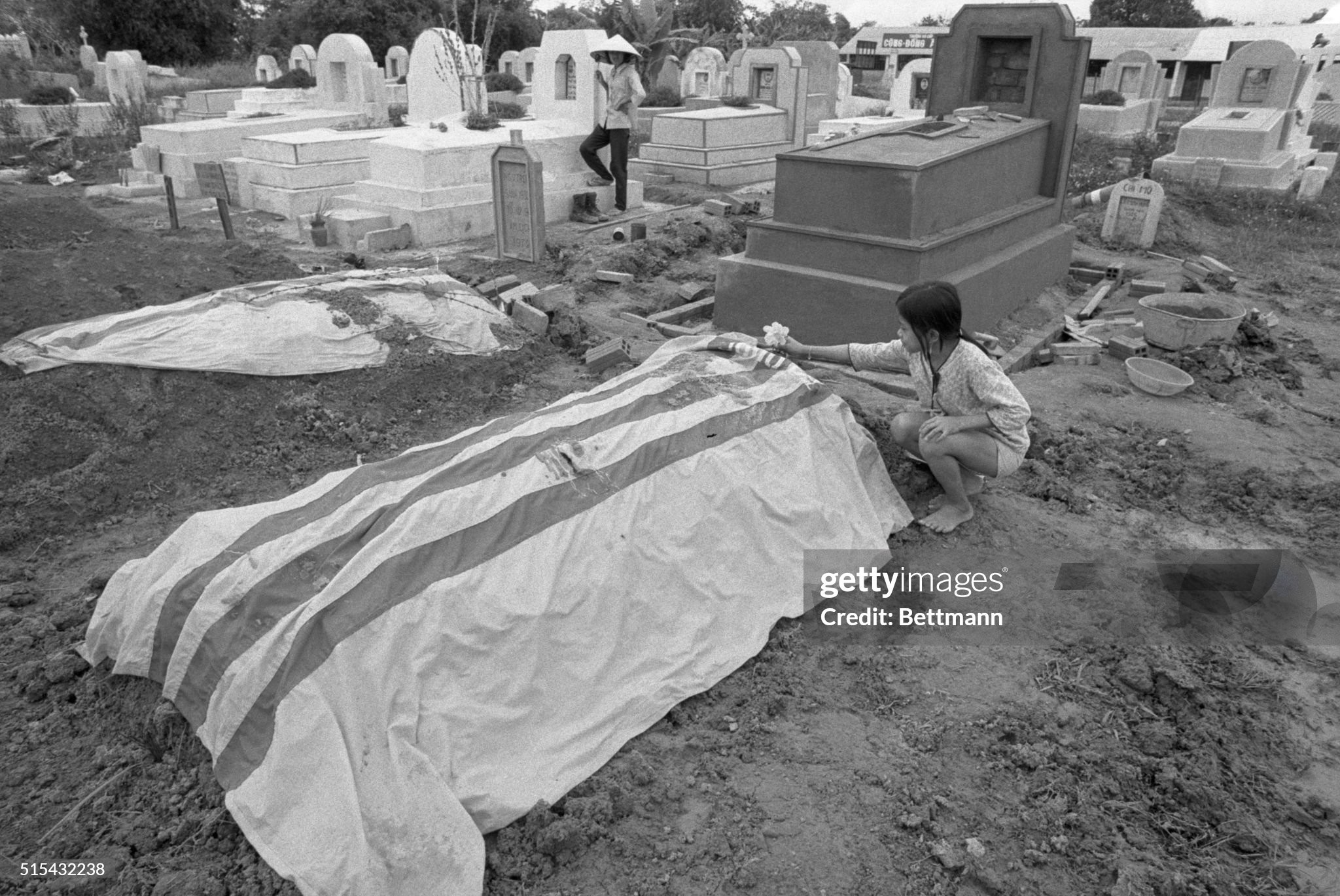 A young girl puts a flower on the fresh grave of her father, killed last month in this village on Highway 13, some 19 miles north of Saigon. | Location: Phu Giao, Vietnam