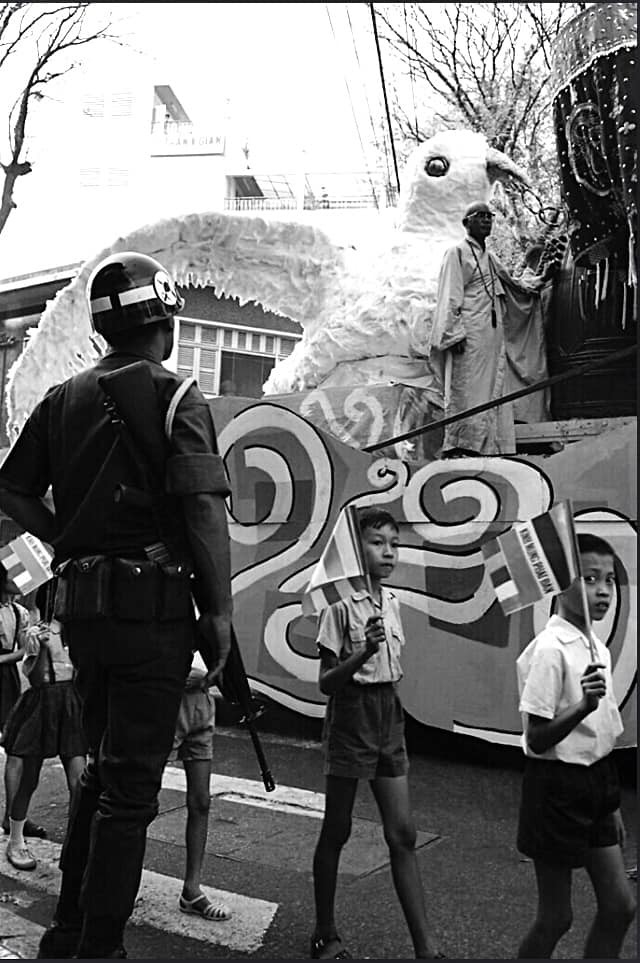 Sài Gòn ngày 23 tháng 2 năm 1969.
Người lính Quân Cảnh giữ an ninh trên đường , nhìn vào chiếc xe hoa lễ Phật Đản ngang qua.