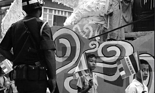 Sài Gòn ngày 23 tháng 2 năm 1969.
Người lính Quân Cảnh giữ an ninh trên đường , nhìn vào chiếc xe hoa lễ Phật Đản ngang qua.