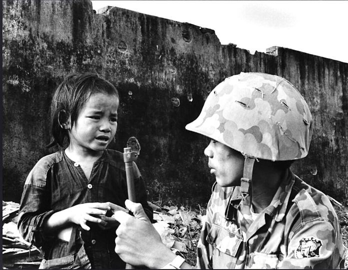 Người lính Cảnh Sát Dã Chiến và em bé Việt Nam trong cuộc hành quân tại thung lũng Quế Sơn , ngày 1 tháng 3 năm 1968.