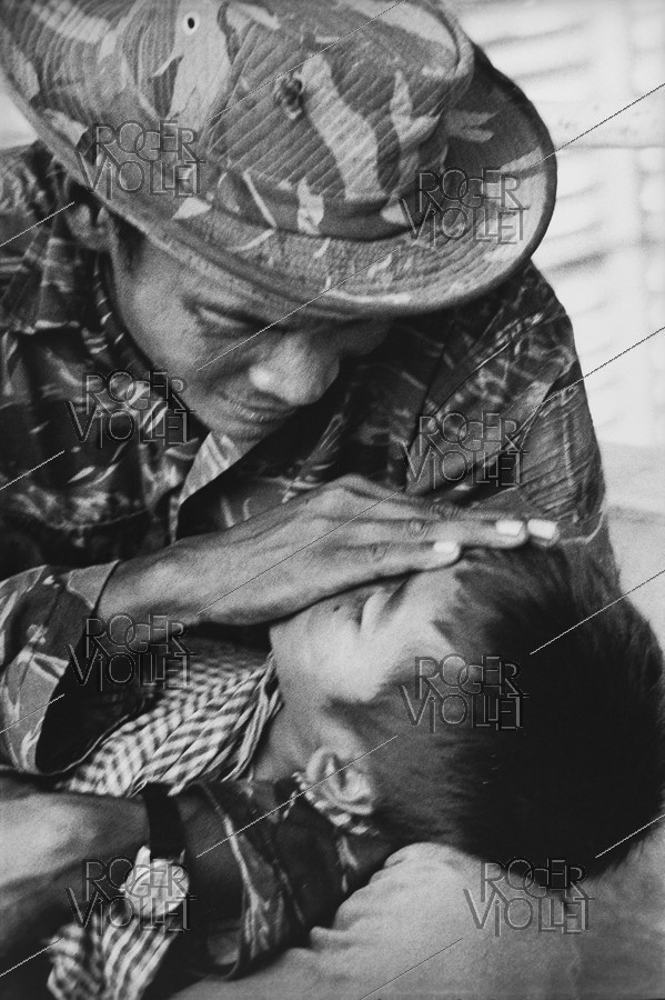 Vietnam War. Wounded child at the hospital with his father, he died a few days later. Saigon, 1975