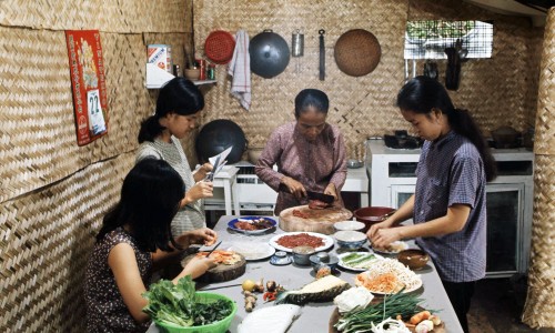 Tấm hình này thể hiện hình ảnh người mẹ cùng 3 cô con gái đang chuẩn bị cho bữa ăn. Bà mẹ đang thái thịt bò, một người con gái đang cắt bánh tráng để cuốn, một người thái cà rốt và một người đang soạn dưa kiệu ra dĩa.

Bên trái là tấm treo lịch của VINATEX, là công ty dệt sợi được thành lập vào đầu thập niên 1960. Tập lịch còn rất mỏng, có thể đó là lịch của năm 1968 đã xé gần hết.