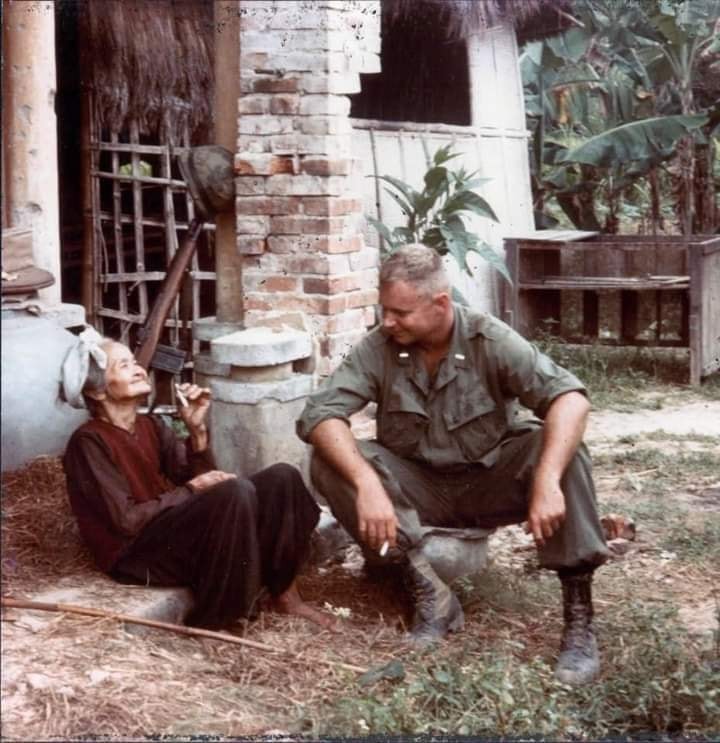 Trung úy Thủy quân Lục chiến Hoa Kỳ, Franklin Cox, thuộc đơn vị Quan sát Tiền Tuyến Pháo binh ngồi hút thuốc, trò chuyện với cụ già làng tên Linh, bà Linh cũng là người ngồi kể và dẫn dắt chính của cuộc trò chuyện giữa hai người, Việt Nam năm 1965-1966.