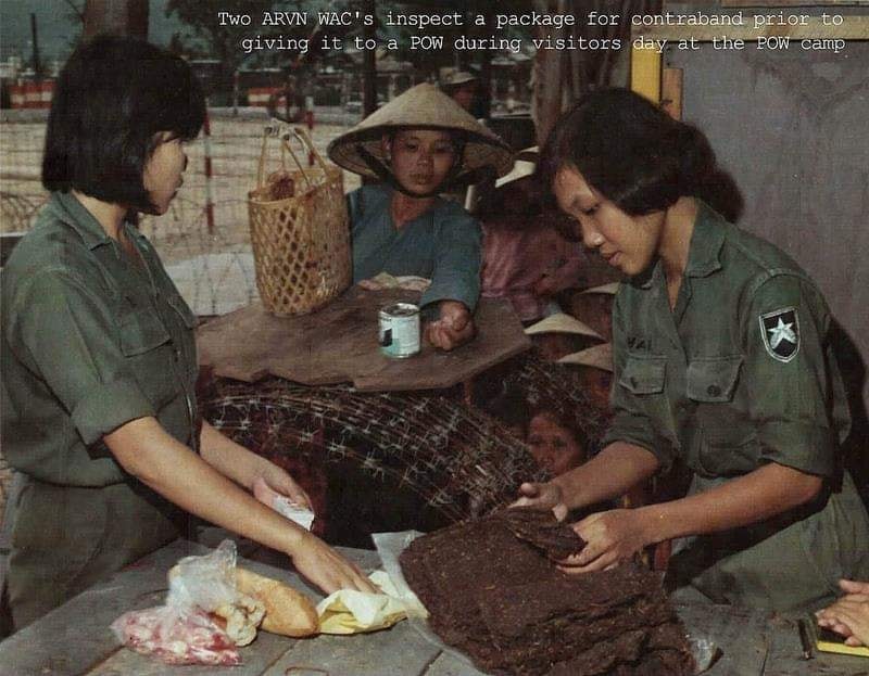 Qui Nhon POW camp - 1968 - Khám xét quà thăm nuôi tại trại tù binh chiến tranh (Two ARVN WAC's inspect a package for contraband prior to giving it to a POW during visitors day at the POW camp)