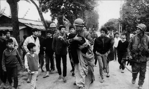Một người lính Hoa Kỳ đang đưa 1 em bé người Việt ra khỏi khu vực giao tranh trong một trận đánh tại Huế...
