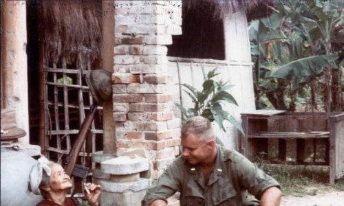 Trung úy Thủy quân Lục chiến Hoa Kỳ, Franklin Cox, thuộc đơn vị Quan sát Tiền Tuyến Pháo binh ngồi hút thuốc, trò chuyện với cụ già làng tên Linh, bà Linh cũng là người ngồi kể và dẫn dắt chính của cuộc trò chuyện giữa hai người, Việt Nam năm 1965-1966.