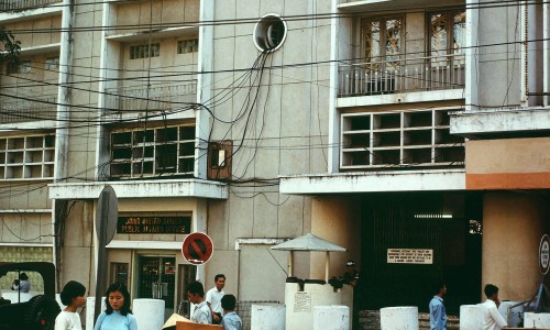 Các gánh hàng rong đang buôn bán tấp nập cho những khách dạo chơi ở gần rạp chiếu phim REX. Phía bên trái là văn phòng Công vụ Liên Hoa Kỳ.
Năm 1968-1969.

(Ảnh: William Ruzin)
