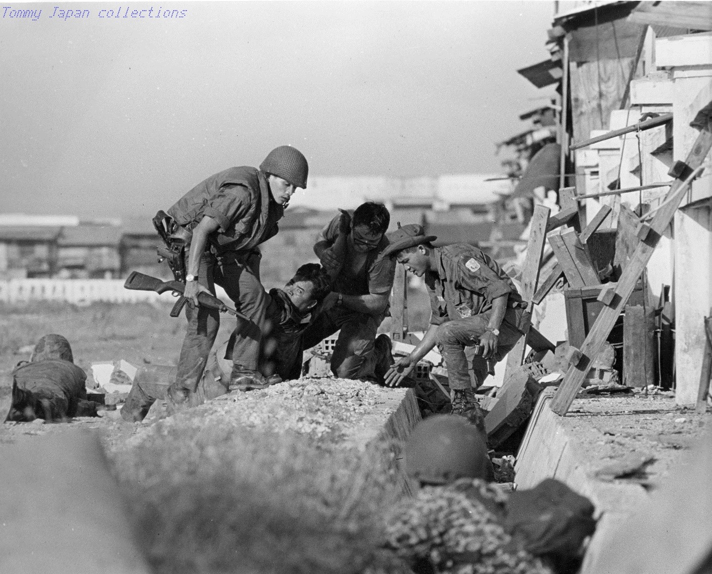 RVN Saigon Sgt. Joe Skalamera, (Phila., PA.), second from right, from the 1500th Det, Air Postal Sq., assists VNAF airmen in moving a wounded VNAF captain while under fire.