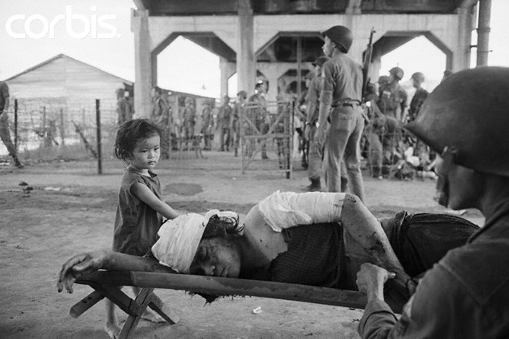 Saigon 7.5.1968 - Một binh sĩ giúp một phụ nữ bị thương - be gái, tại một trạm sơ cứu ở Chợ Lớn, trong khi giao tranh ác liệt trong thành phố