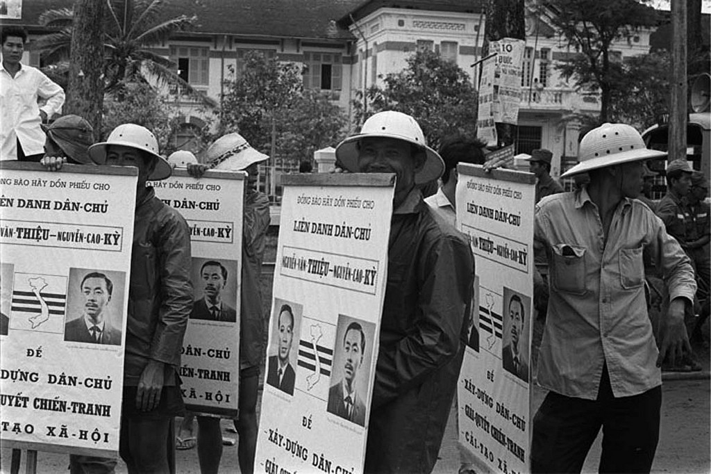 1967 Hired pedicab drivers carrying political posters for Ky and Thieu