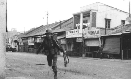 Cholon 1968 - A Vietnamese paratrooper grenadier darts for cover while advancing on Viet Cong positions in the Phu Nhuan section of the capital city -  Photo by Douglas Pike Photograph Collection