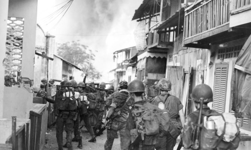 Members of the 7th Bn., ARVN Airborne Div., leave the flaming village of Tan Son Nhut after conducting a sweep - Photo by Donald Jellema Collection
