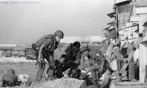 RVN Saigon Sgt. Joe Skalamera, (Phila., PA.), second from right, from the 1500th Det, Air Postal Sq., assists VNAF airmen in moving a wounded VNAF captain while under fire.