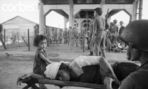 Saigon 7.5.1968 - Một binh sĩ giúp một phụ nữ bị thương - be gái, tại một trạm sơ cứu ở Chợ Lớn, trong khi giao tranh ác liệt trong thành phố