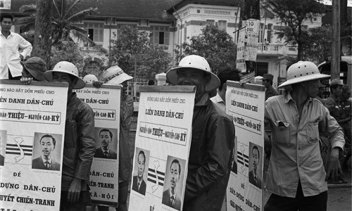 1967 Hired pedicab drivers carrying political posters for Ky and Thieu